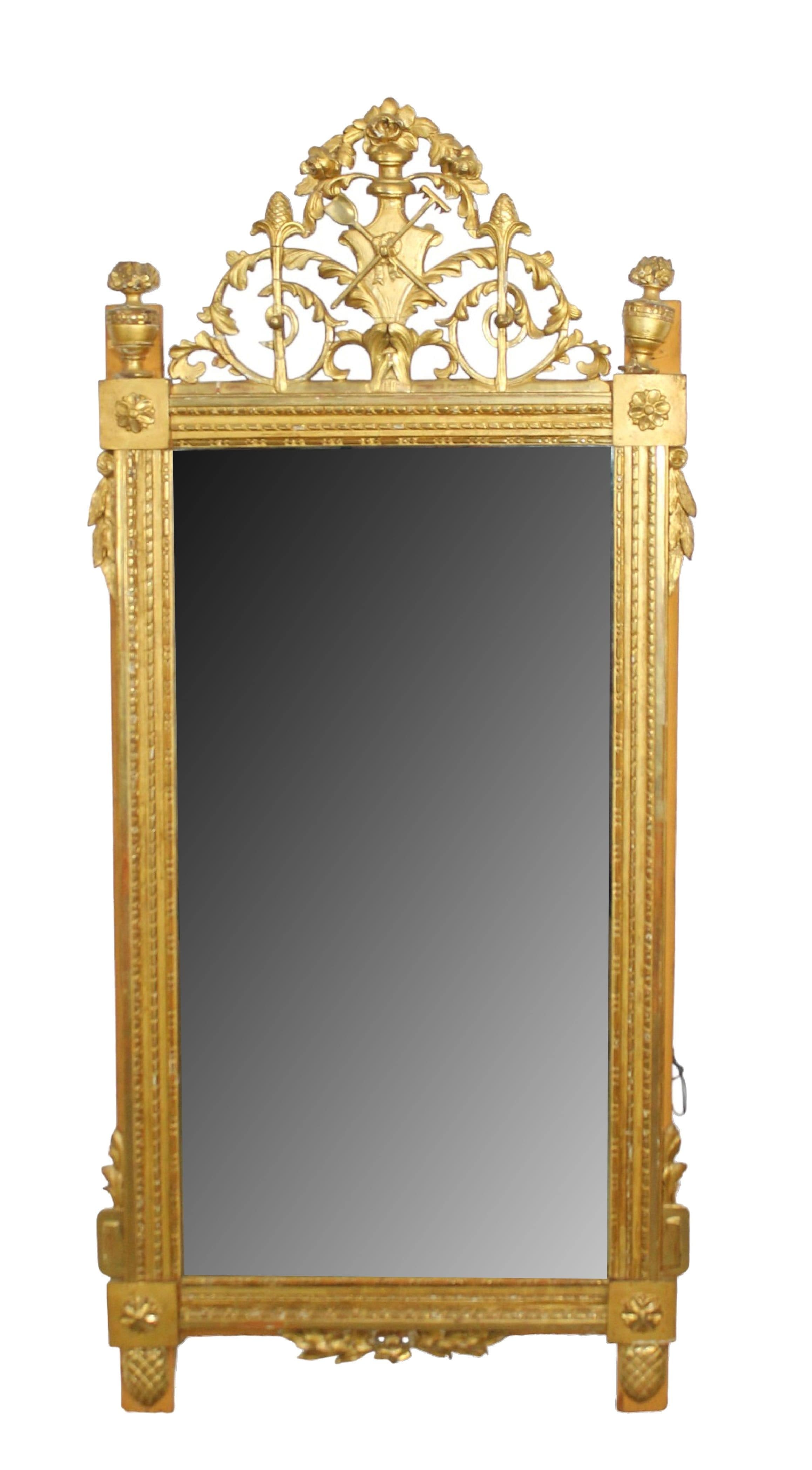 French Louis XVI gold leaf mirror with elaborate pierced crest with garden attributes